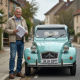 Homme d'âge moyen avec documents et Citroën 2CV vintage