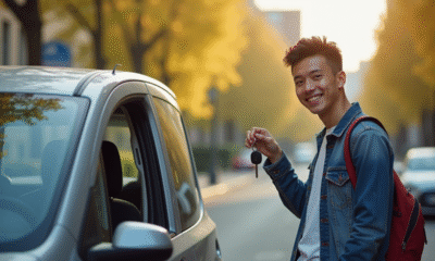 Jeune conducteur souriant avec clés près d'une petite voiture moderne