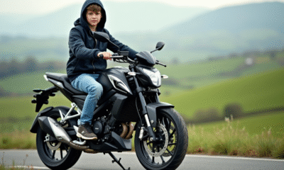 Jeune garçon en jeans et veste en hoodie sur une moto 50cc en campagne